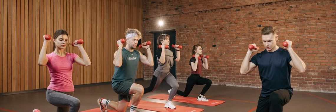 Indoor group workout session with dumbbells focusing on strength and fitness.